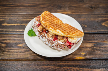 Sweet waffles with nutella cream and banana, strawberry slices