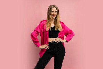 Fasgionable blond woman in stylish summer clothes posing on pink background in studio.