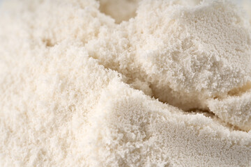Heap of protein powder on white background. Scoops Of Protein Powder. Measuring spoon and heap of vanilla protein powder.