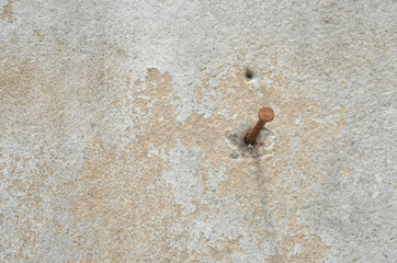 rusty nail on the cement wall