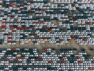 Giant car parking aerial view, colorful cars are standing in straight rows on the asphalt parking lot, car factory
