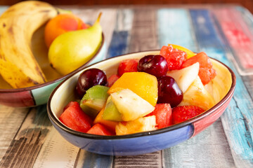 closeup of multicolored bowl with healthy fresh summer fruit