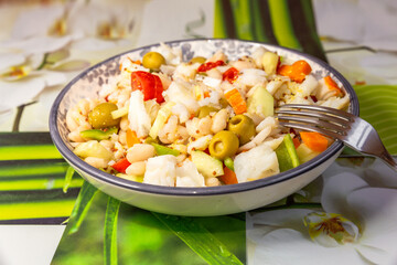 close up of plate with white beans and codfish salad . Ingredients bell pepper,onion and olives