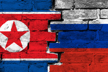 Concept of the relationship between North Korea and Russia with two painted flags on a damaged brick wall