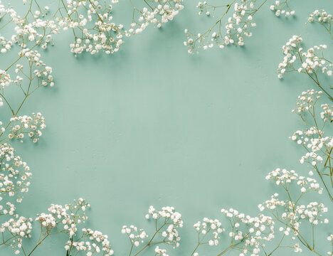 Flowers composition. White flowers on turquoise blue background. Wedding mockup with small flowers. Flat lay, top view, frame. Gypsophila Baby's-breath flowers