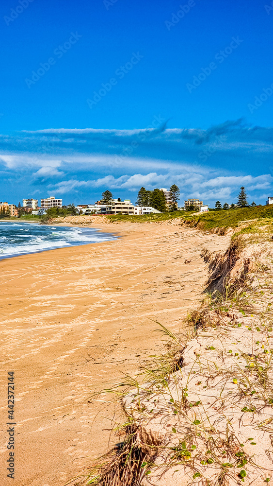 Canvas Prints vertical shot of splashing foam waves with the coastal town in the background