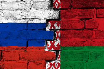Concept of the relationship between Russia and Belarus with two painted flags on a damaged brick wall