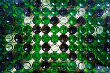 Stacked glass bottles of different colors, viewed from the bottom 