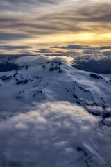 Obraz premium Aerial View from Airplane of Canadian Mountain Landscape in Spring time. Colorful Sunset Sky Artistic Render. North of Vancouver, British Columbia, Canada.