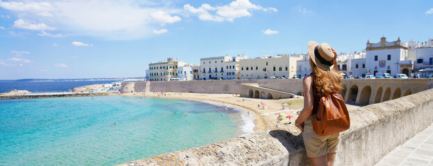 Traveling in Italy. Panoramic view of female backpacker with hat in Gallipoli village, Salento,...