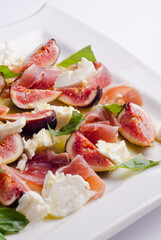 Fresh salad with figs and jamon. Delicious lunch mozzarella salad. Summer salad. Healthy eating. The right food. A light mix of farm ingredients