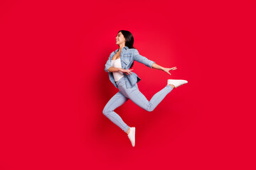 Fototapeta na wymiar Full length body size view of attractive cheerful girl jumping dancing moving modern isolated over bright red color background