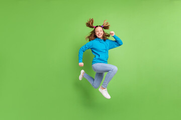 Full length photo of brunette ponytail haired little girl jump up run empty space blue hoodie...