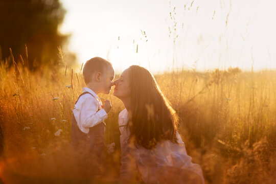 Motherhood. Toddler Toddler Boy With Mom In A Field At Sunset In Summer, Beautiful Summer Photo, Blur And Soft Focus, Very Warm Photo, Toning