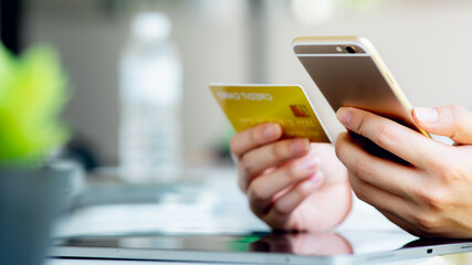 Close up woman hand using credit card and tablet for buying online shopping at home ,payment,buying and online shopping concept.