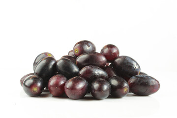 Pile of dark grapes isolated on white background. 