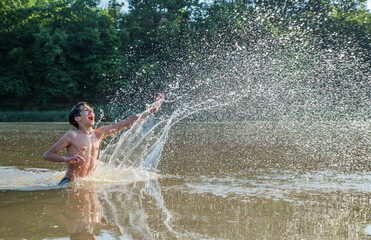 Teenager splashes water in the river.