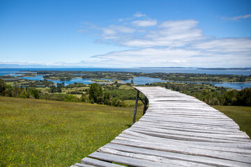 Fototapeta na wymiar Dock of the islands viewpoint, located on Mechuque Island, Chiloé in southern Chile. With blue sky with some clouds