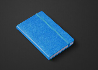 blue closed notebook isolated on black
