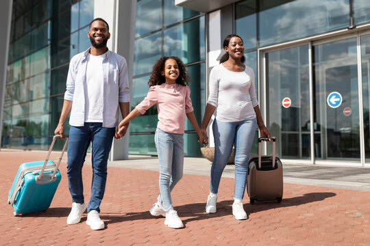 Happy Black Family Traveling With Kid, Walking Out Modern Airport