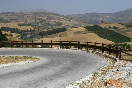 Winding road with a sharp bend in the countryside. Sicily, Italy. Copyspace for product placement