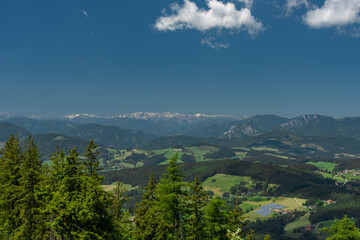 Pass near Niederer Schockl hill with green meadows and fences in Austria