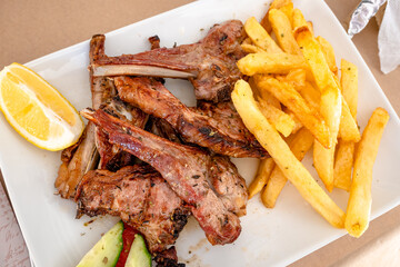 Grilled lamb chops served with fries in restaurant. Traditional Greek dish.
