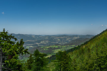 Pass near Niederer Schockl hill with green meadows and fences in Austria