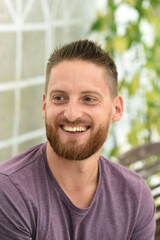 Fototapeta premium young bearded man smiling with purple clothes