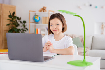 Portrait of attractive cheery smart diligent girl using webcam attending lesson watching video tutorial at light white flat home house indoors