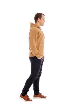 side view of walking handsome man in beige hoodie isolated on white