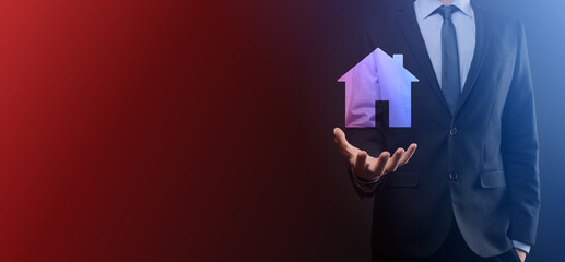 Businessman male hand holding house icon on blue background. Property insurance and security concept.Real estate concept.Banner with copy space.