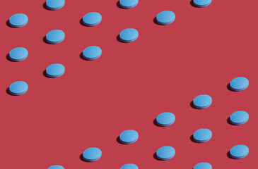 Fototapeta na wymiar Vibrant colorful pattern of blue medicine pills on red background. Creative concept of overdose medicine usage and addiction to health tests.