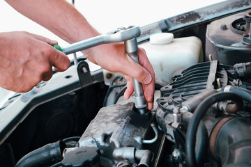 Car repair. Auto mechanic working on car engine in mechanics garage. Repair service. close-up shot