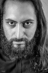 black and white portrait of a young middle eastern businessman with beard and long hair