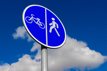 Traffic road sign Separate lanes for pedestrians and cyclists against sky background
