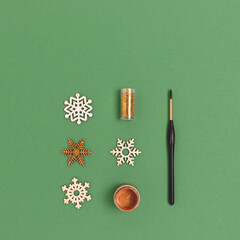 Fototapeta na wymiar Layout of wooden New Years decorations on a green background. Equipment for coloring Christmas toys.