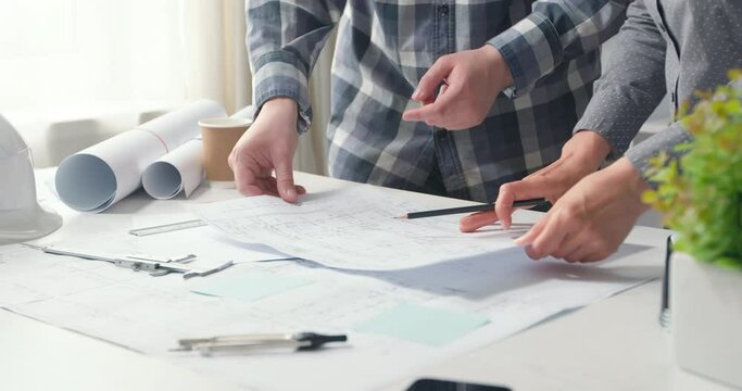 Architects are working on a building construction sketches design project. Engineers draw blueprints on the desktop. 4K.