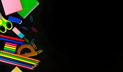 Multicolored assorted stationery on black background