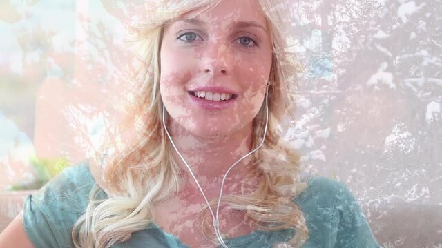 Animation of smiling woman wearing earphones listening to music, over trees in sunshine