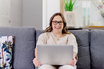 young woman with Down Syndrome using computer at home