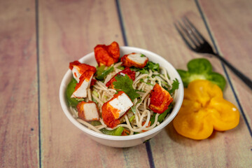 Delicious paneer noodles on a white bowl