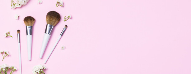 Set of make up brushes on pink pastel background long banner format.