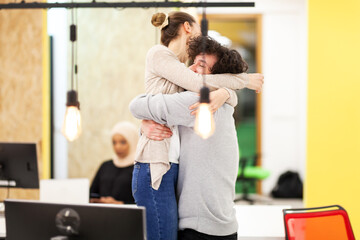 Fototapeta premium Three caucasian colleagues cheering for job well done in a modern office with decorative hanging lightbulbs.