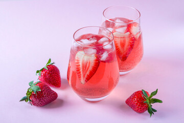 Two glasses of Cooling strawberry Sangria with sparkling wine, strawberry, ice cubes in champagne glass. Refreshing summer alcoholic cocktail drink , lemonade or ice tea. Copy space for text