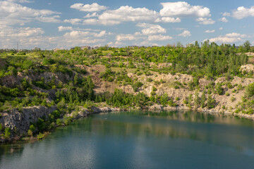 landscape of a granite quarry against a summer cloudy sky