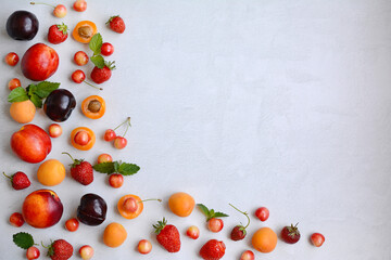 Naklejka na ściany i meble Seasonal berries and fruits - cherries, strawberries, peaches, plums, apricots on a white background. Flat lay, copy space