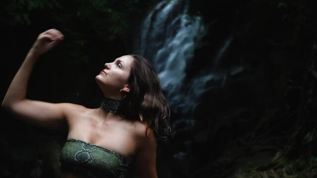 Young woman posing with the waterfall on the background
