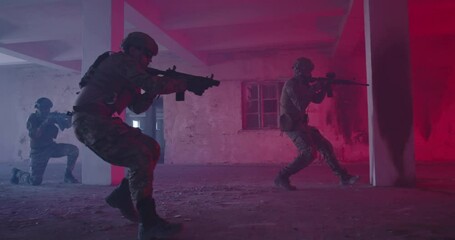 Masked Team of Armed Modern Warfare Soldiers Team Move in Tactical Formation in a Dark Urban Battlefield Indoors.Soldiers Squad with Rifles and Flashlights in action.