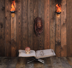ancient open book with skull on wooden background